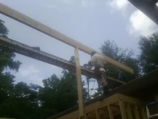 Carpenter setting a ridge beam over a new addition frame — Ice Dam Removal by Roofing Brothers in Guernsey
